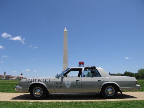 1991 Ford LTD Crown Victoria - silver Rhode Island State Police sedan with a red roof light bar is parked on a path in front of the Washington Monument.