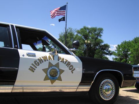 1991 Ford LTD Crown Victoria - close-up shows the California Highway Patrol gold star emblem and Highway Patrol lettering on a black-and-white car door.