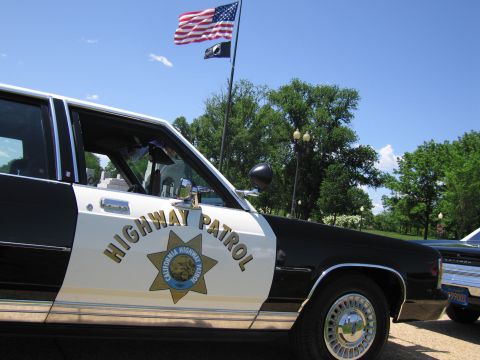 1991 Ford LTD Crown Victoria - front fender and door of a black-and-white car show the California Highway Patrol gold star and Highway Patrol lettering.
