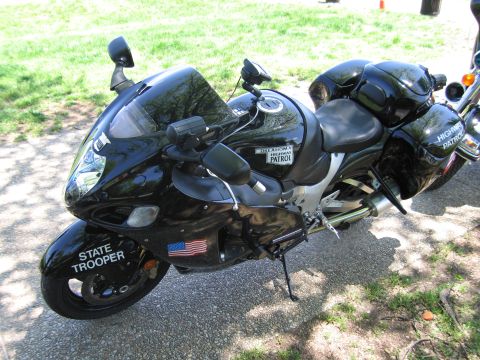 1991 Ford LTD Crown Victoria - black State Trooper sportbike marked Highway Patrol carries an Oklahoma front plate and US flag decal on a paved path.