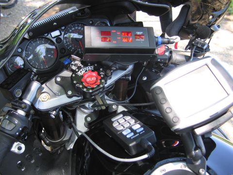 1991 Ford LTD Crown Victoria - Detailed view of a black motorcycle's gauges, red steering damper, digital radar readout, and auxiliary control pads.