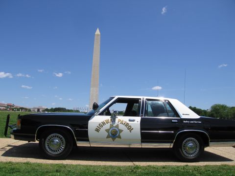 1991 Ford LTD Crown Victoria - black-and-white Ford police sedan with a Highway Patrol star badge sits on grass in front of the Washington Monument.