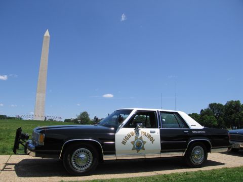 1991 Ford LTD Crown Victoria - black-and-white Ford police sedan marked Highway Patrol with a gold star badge parked by the Washington Monument.
