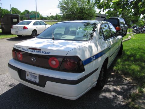 1991 Ford LTD Crown Victoria - Rear three-quarter view of a white Chevrolet police sedan lettered United States Park Police with unit number 354.
