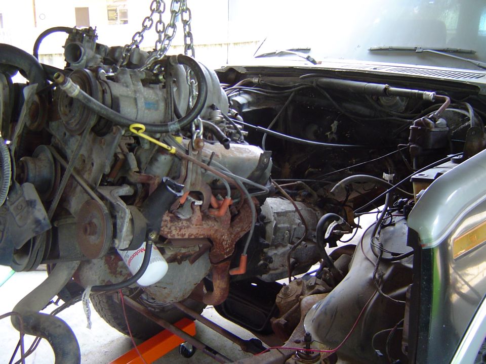 Engine being lifted by chains from a 1986 Ford Bronco engine bay