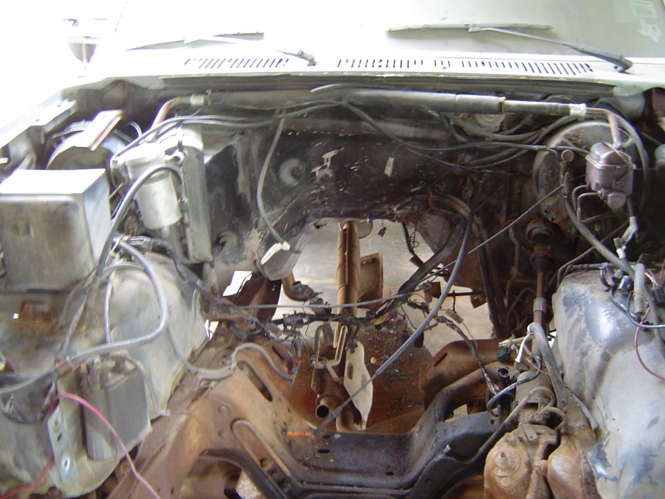 Disassembled engine bay with exposed wiring and frame components. Supermotors.net logo visible
