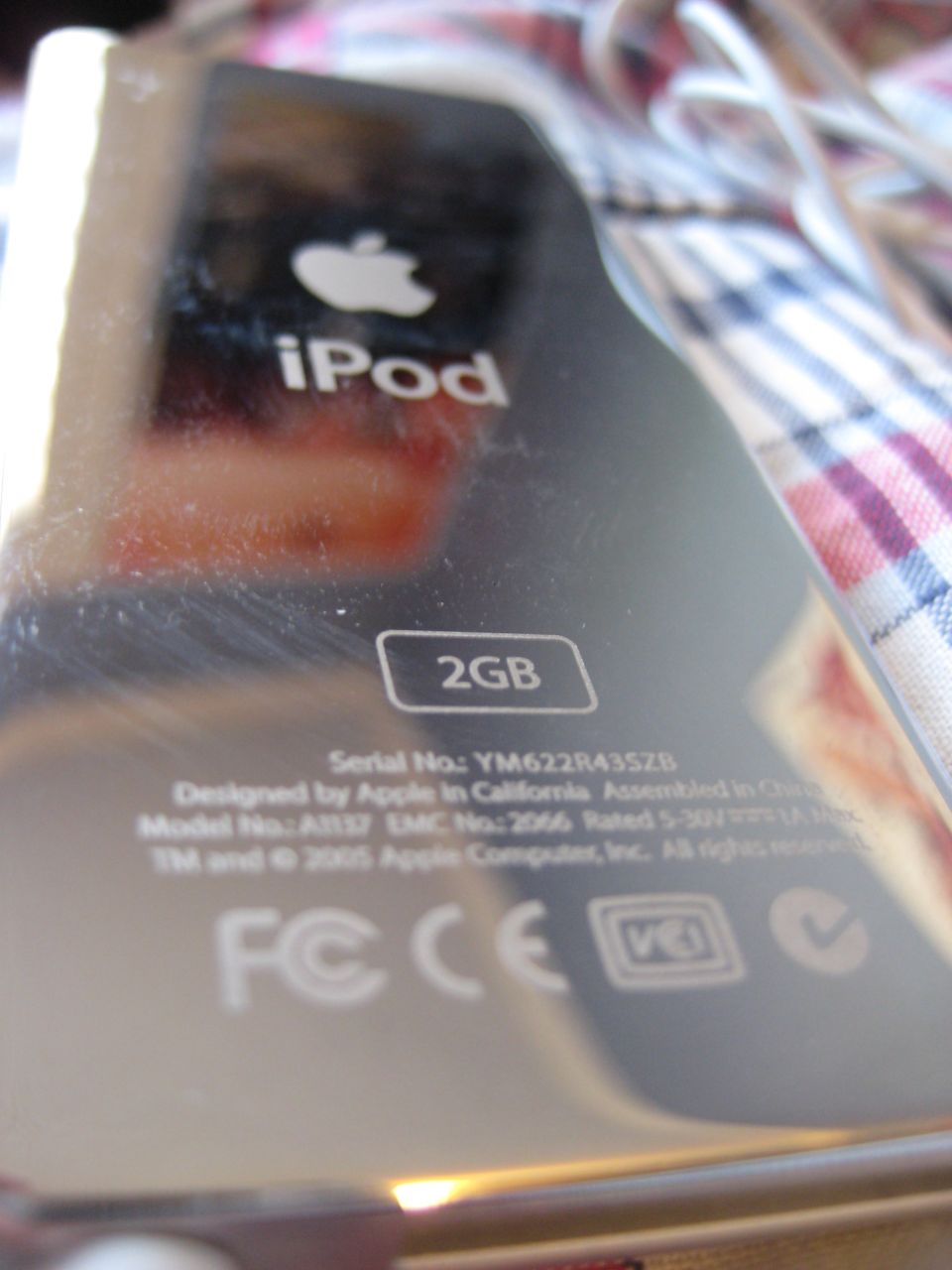Back of an iPod showing Apple logo, 'iPod', '2GB', serial number, and regulatory markings