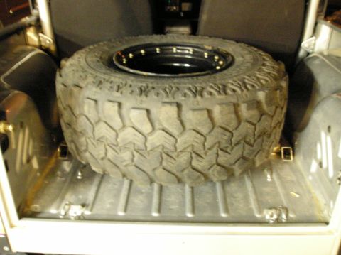 1986 Toyota Hilux - A spare tire is stored in the cargo area of a vehicle.