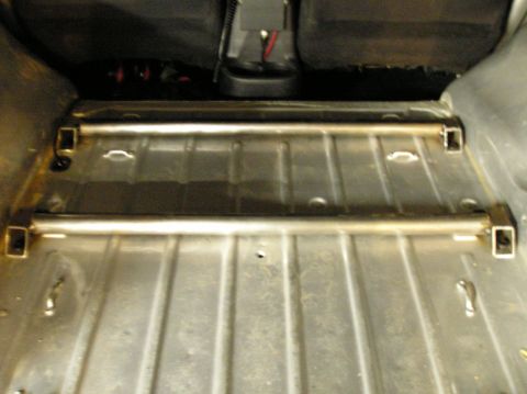 1986 Toyota Hilux - The cargo area of a vehicle features two parallel metal bars, possibly for securing cargo.