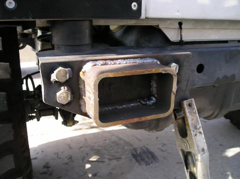 1986 Toyota Hilux - Custom trailer hitch receiver welded onto a vehicle's frame, showing bolts and metalwork.