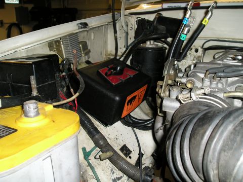 1986 Toyota Hilux - Close-up view of a vehicle's engine bay, showing the battery, wiring, and various engine parts.