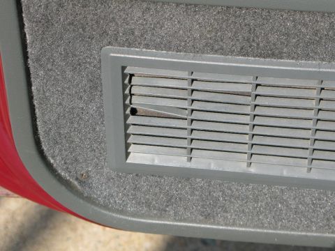 1991 Ford F-150 - Interior door panel detail showing a gray air vent and carpet trim.