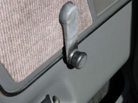 1991 Ford F-150 - The interior door panel features a manual window crank mechanism and textured fabric upholstery.