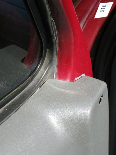 1991 Ford F-150 - Close-up of a vehicle's interior door frame, showing red paint and gray trim.