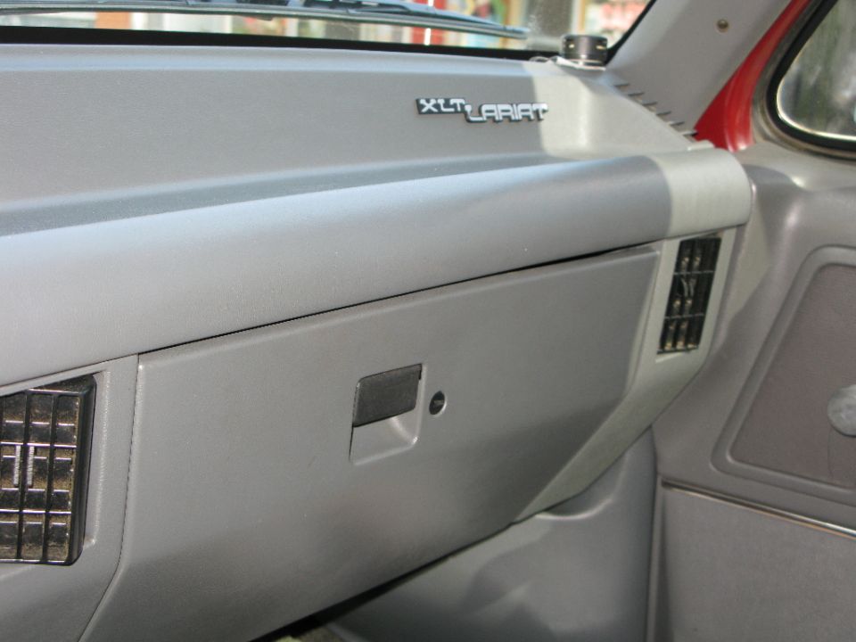 Dashboard of a 1991 Ford F-150, showing the glove box and XLT Lariat trim
