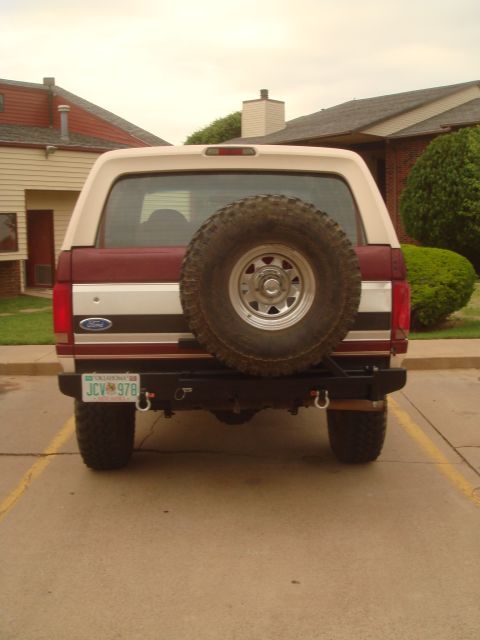 1992 Ford Bronco - Rear view of a 1992 Ford Bronco with a spare tire on the back and a custom bumper.
