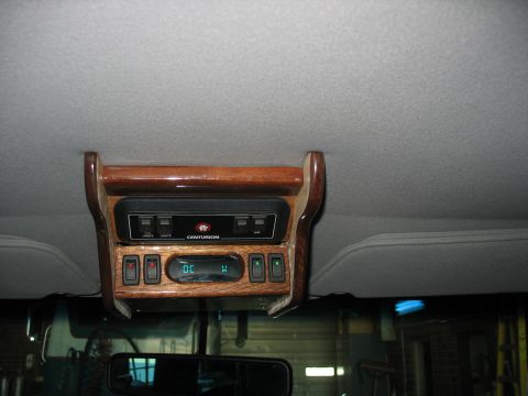 1995 Ford C-350 (Centurion Conversions) - Interior view of an overhead console with wood trim and various control switches.