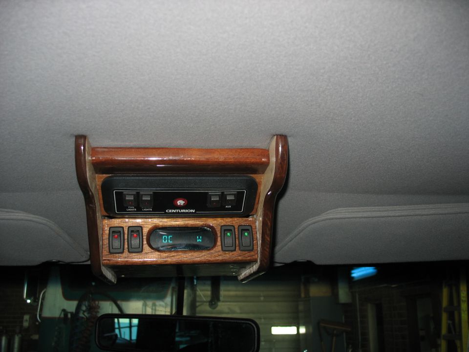 Overhead console marked Centurion with digital compass and switch banks in woodgrain trim