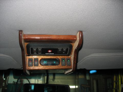 1995 Ford C-350 (Centurion Conversions) - The interior overhead console features wood trim, multiple switches, and a digital display.