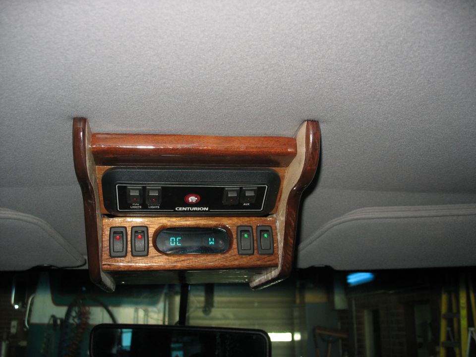 Wood-grain Centurion overhead console with rocker switches and digital compass/temp display