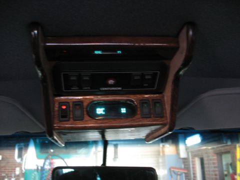 1995 Ford C-350 (Centurion Conversions) - The overhead console features wood trim, climate controls, and a 'CENTURION' badge, indicating a custom conversion.