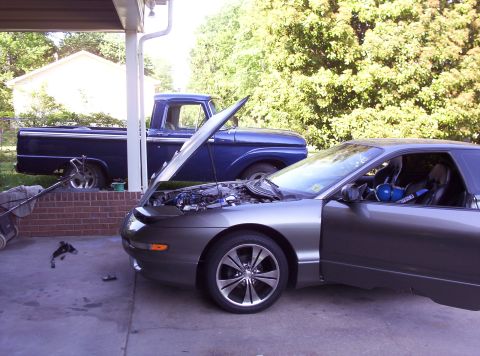 1995 Ford Probe - A gray Ford Probe is parked in front of a blue Ford F-Series truck, both with hoods open.
