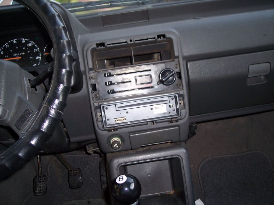 Car interior with aftermarket stereo, black steering wheel, and an 8-ball shift knob