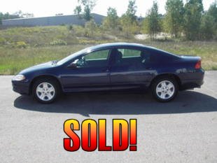 2001 Ford Crown Victoria - This dark blue Dodge Intrepid is shown from the side, parked on asphalt with trees and a building in the background.