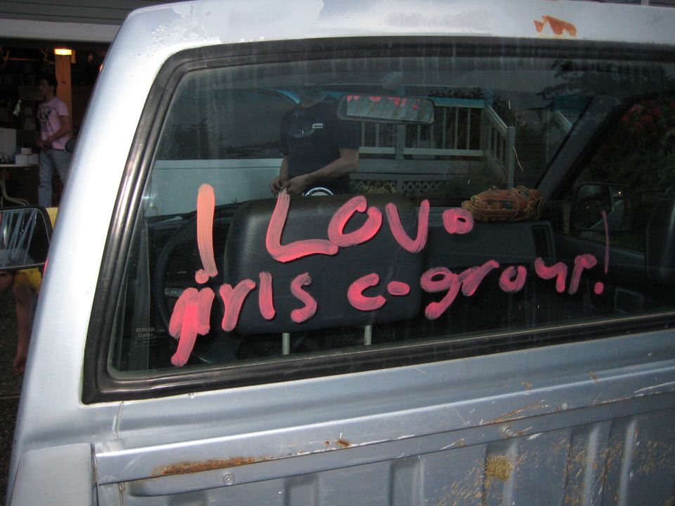Rear window of a pickup truck with pink writing: "I LOVE girls c-group!"