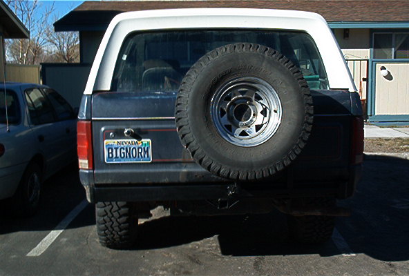 Rear of dark blue Ford Bronco with white top and spare tire, Nevada plate BIGNORM
