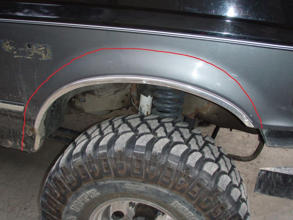 Front fender arch with red cut line drawn on, coil spring and MTZ mud tire below