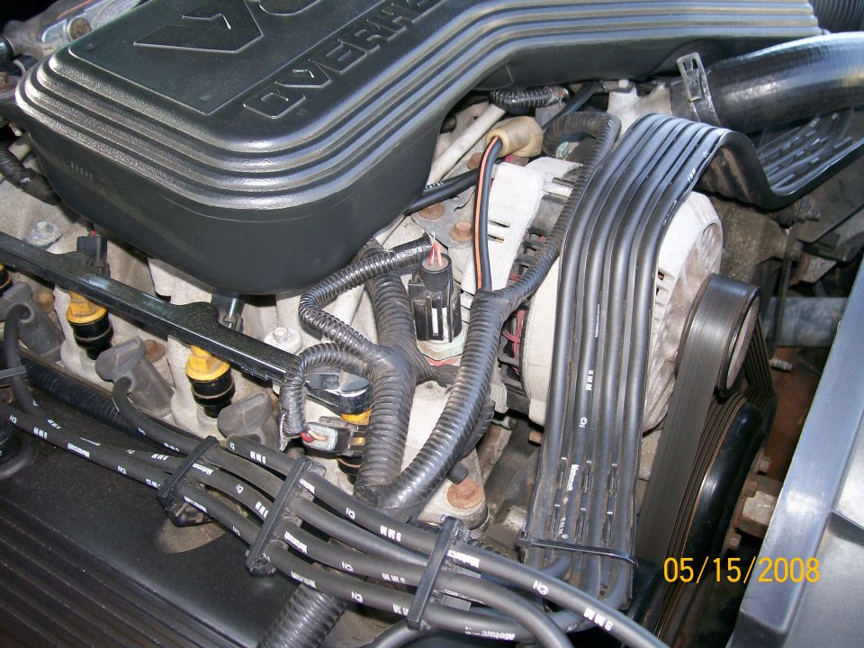 1995 Mercury Grand Marquis engine bay with fuel injectors, spark plug wires, and alternator.