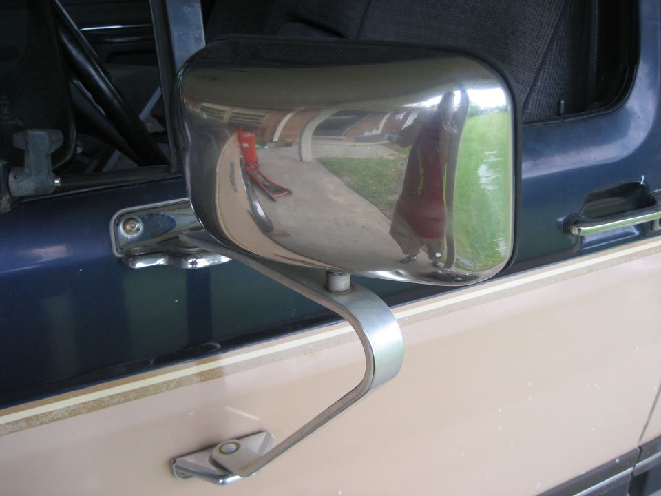 Chrome swing-arm side mirror on the door of a two-tone blue and tan truck