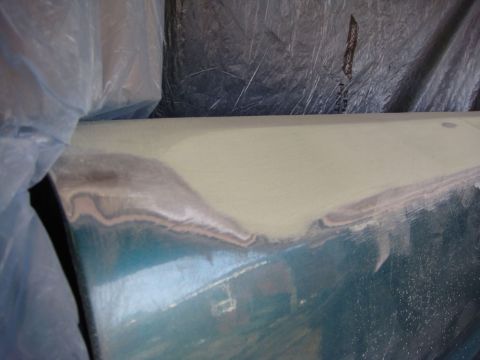 1996 Ford Bronco - Close-up photograph of a sanded body panel and masking during paint prep, not a technical document.