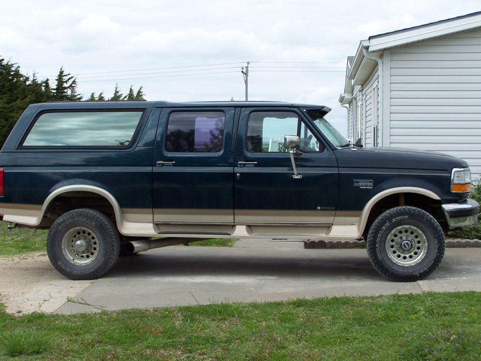 Dark green four-door Ford Centurion conversion wagon, full side profile on driveway