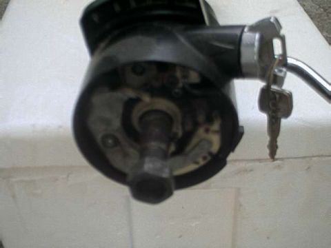 1976 Ford Ranchero - A close-up view of a vehicle's ignition switch assembly with a key inserted. The assembly is black and silver, and the key is metallic.