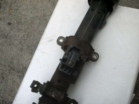 1976 Ford Ranchero - This is a close-up, angled shot of a black steering column assembly with a metal bracket and electrical connector attached. The assembly is…