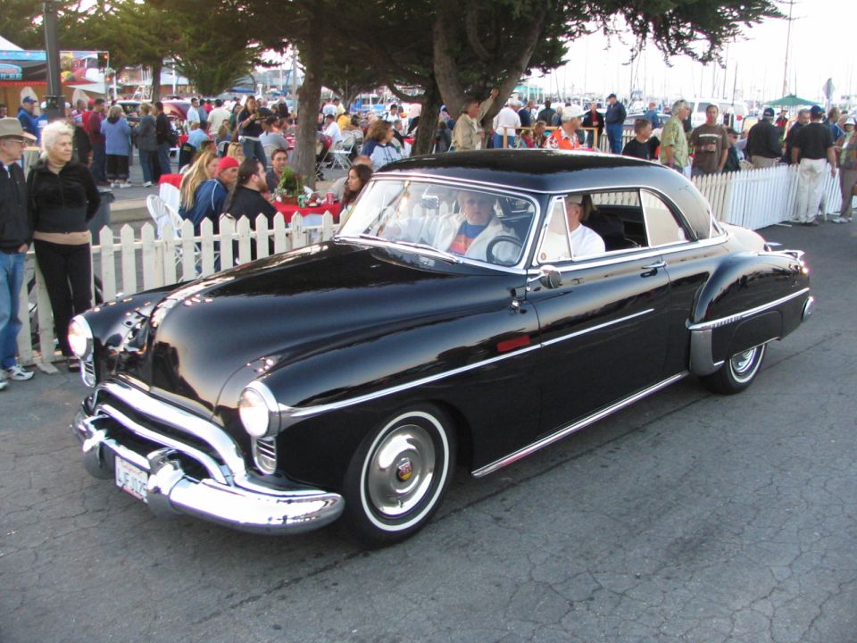 Black classic car with chrome trim parked outdoors