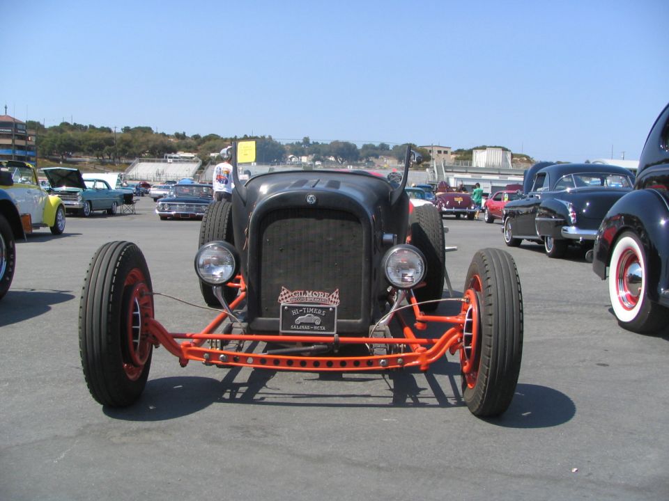 Front view of a black hot rod with an orange frame and red wheels.