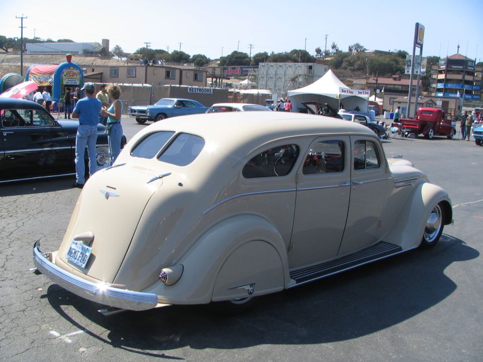 Tan vintage sedan with chrome accents parked on asphalt.