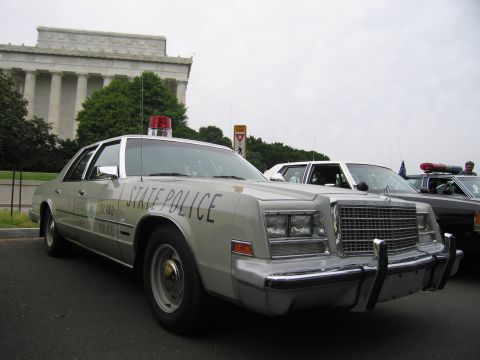 1991 Ford LTD Crown Victoria - silver Chrysler 'State Police' sedan with a red roof beacon sits in front of the Lincoln Memorial columns.