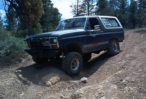 1986 Ford Bronco - This 1980s Ford Bronco navigates a challenging off-road terrain.