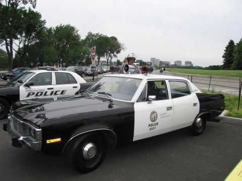 1991 Ford LTD Crown Victoria - Side view of a black-and-white AMC LAPD police sedan with twin roof loudspeakers, parked with a person inside.