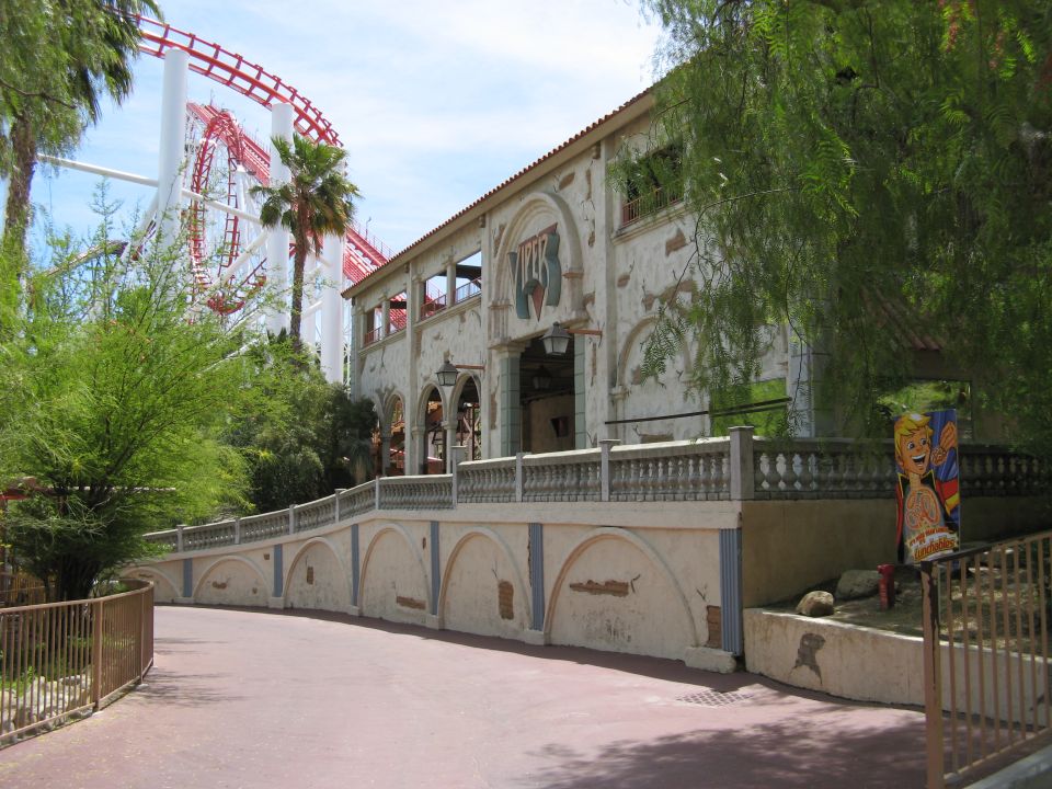 Amusement park scene with roller coaster and building.