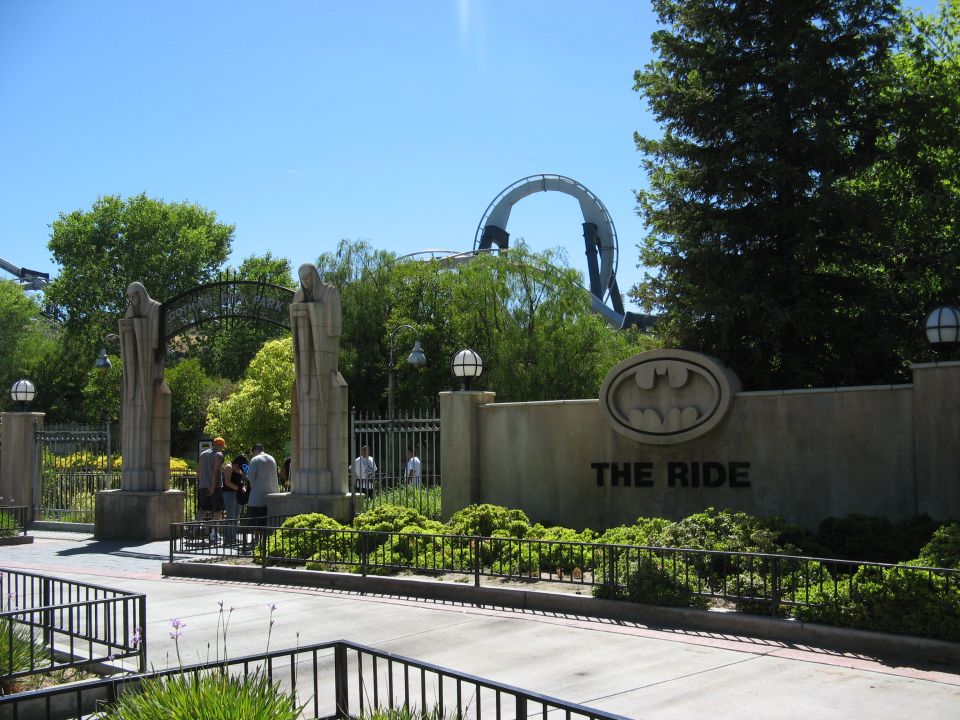Batman logo and "THE RIDE" sign at an amusement park.