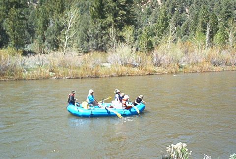 1986 Ford Bronco - A group enjoys a rafting trip on a river surrounded by natural scenery.