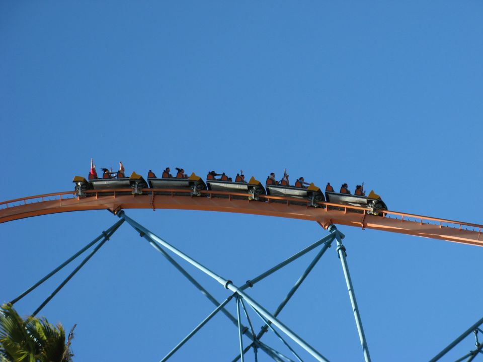 Roller coaster train on orange track against blue sky
