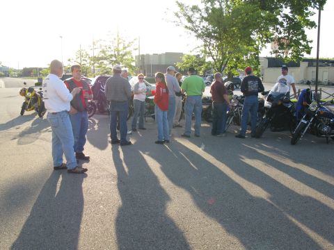 1985 Ford LTD Crown Victoria - Photograph of a group of riders gathered in a parking lot, not a technical document.