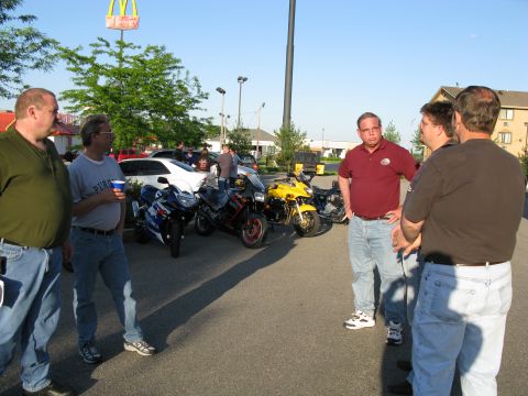 1985 Ford LTD Crown Victoria - Photograph of riders talking in a parking lot, not a technical document.