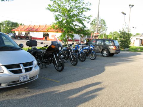 1985 Ford LTD Crown Victoria - Photograph of several motorcycles and a minivan parked in a lot, not a technical document.